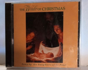 May include: A CD case with the title "The Wonder of Christmas" in gold lettering. The cover art features a religious scene with figures and a baby. The text "Sung by the Daughters of St. Paul" is at the bottom.