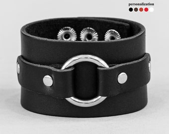 May include: Black leather bracelet with a silver ring and decorative studs.