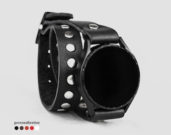 Peut inclure: Bracelet de montre en cuir noir avec des clous argentés. Le bracelet est double et a un cadran de montre noir.
