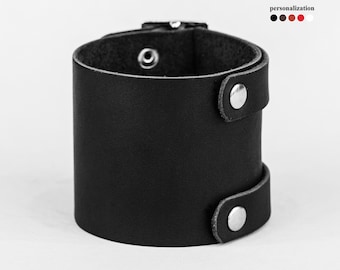 May include: Black leather cuff bracelet with silver snaps and a buckle closure.