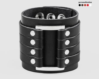 May include: Black leather cuff bracelet with silver studs and a silver metal buckle.