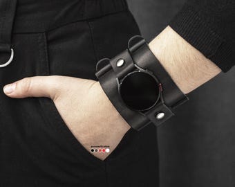 May include: Black leather watch band with silver accents and a black watch face. The band is adjustable and has a buckle closure.