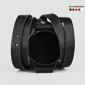 May include: A black leather watch band with a wrap-around design. The band is made of multiple layers of leather and has a simple, minimalist style.