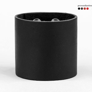 May include: A black leather cuff bracelet with silver snaps.