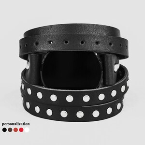 May include: Black leather wrap bracelet with silver studs. The bracelet is adjustable and has a minimalist design.