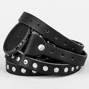 May include: A black leather watch with a silver face and a studded band.