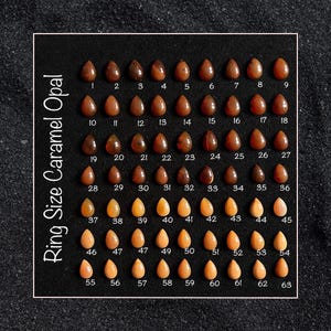 May include: A chart of caramel opal ring sizes, ranging from size 1 to size 63. The chart is laid out in rows and columns, with each size represented by a teardrop-shaped opal stone.