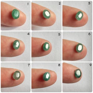 Pu&ograve; includere: Nove pietre preziose verdi di forma ovale, ciascuna tenuta da un dito, sono disposte in una griglia. Le pietre preziose sono probabilmente smeraldi o peridoti.