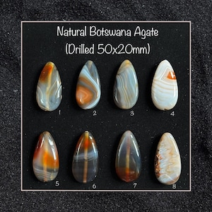 May include: Eight natural Botswana agate stones, each with a different pattern of brown, white, and grey banding. The stones are drilled and measure 50x20mm. Natural Botswana Agate (Drilled 50x20mm)