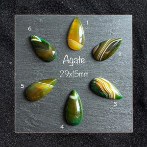 May include: Six teardrop-shaped agate gemstones arranged in a circle, each featuring unique banded patterns in shades of green, yellow, and brown. The text Agate 29x15mm is centred among the stones, which are numbered one through six.