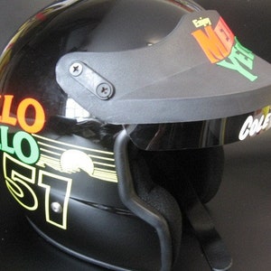 Puede incluir: Casco de moto negro con visera. El casco tiene texto colorido que dice "HELLO" y "57". La visera tiene las palabras "Enjoy New Year" y el nombre "Cole".