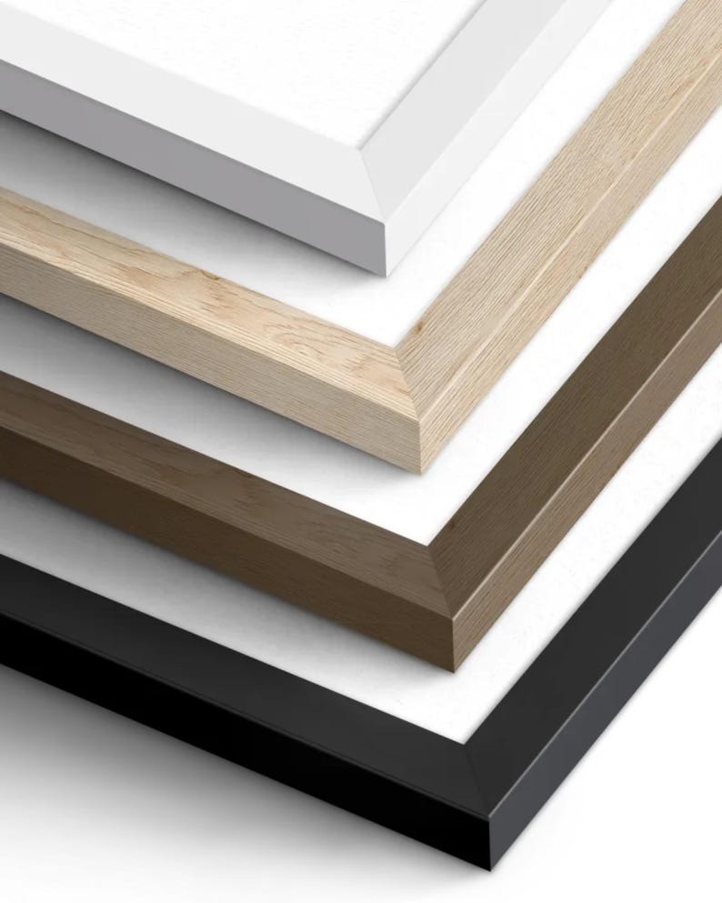 May include: Four picture frames in different colours and sizes, stacked on top of each other. The top frame is white, the second frame is light wood, the third frame is brown, and the bottom frame is black.