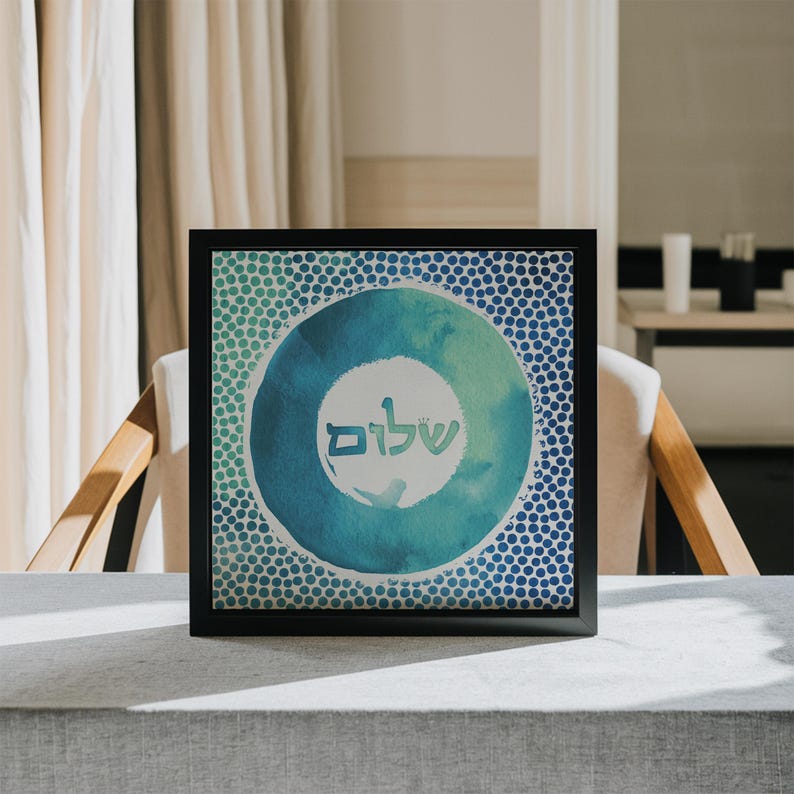 May include: A framed print featuring a blue and green watercolour circle design. The circle has a white background with the Hebrew word "Shalom" written in black.