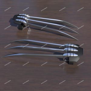 May include: A pair of silver-colored retractable claws with black handles. The claws are extended and pointed.