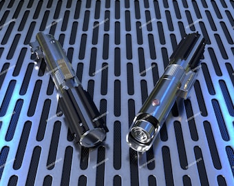 May include: Two silver and black lightsabers with a textured surface, lying on a silver and black patterned surface.