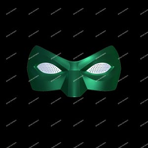 Puede incluir: Una máscara verde con aberturas para los ojos de malla blanca. La máscara tiene forma puntiaguda y está sobre un fondo negro. La máscara es de color verde liso y brillante.