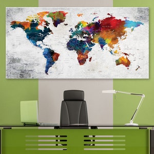 Puede incluir: Una impresi&oacute;n de mapa del mundo colorido con acentos de acuarela cuelga sobre un escritorio de oficina moderno con una silla de oficina de cuero negro, una l&aacute;mpara de escritorio verde y un escritorio verde con una tapa de vidrio.