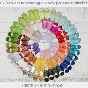 May include: A circular arrangement of numerous leather babouche slippers in a wide variety of colors including green, pink, blue, red, orange, yellow, brown, white, and metallic tones. Text at the top reads: For 36 fun colours in the same style babouche, please see our other listings. Text at the bottom reads: etsy.com/uk/listing/600172528.