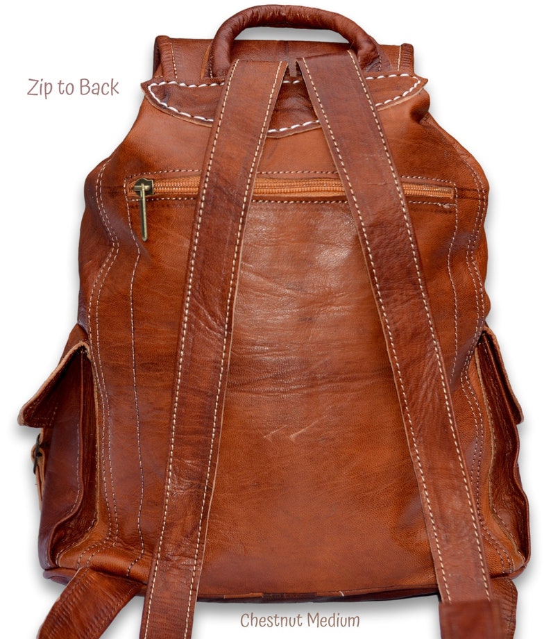 May include: Chestnut brown leather backpack with adjustable straps and a zippered pocket on the back. The text "Chestnut Medium" is visible at the bottom of the image.
