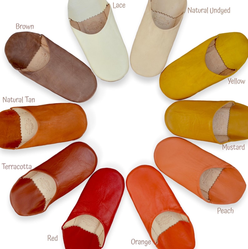 Peut inclure: Une collection de chaussons en cuir de diff&eacute;rentes couleurs : marron, cr&egrave;me, naturel, jaune, moutarde, p&ecirc;che, orange, rouge, terre cuite et beige. Chaque chausson a un bout arrondi et un int&eacute;rieur contrast&eacute;.