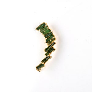 Puede incluir: Un pendiente de aro de oro con una cascada de piedras preciosas verdes. Las piedras preciosas est&aacute;n talladas en largos rect&aacute;ngulos delgados y est&aacute;n dispuestas en forma escalonada.