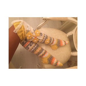 May include: Yellow and gray knitted knee-high socks with white lace and yellow flower embellishments.