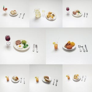 Puede incluir: Una colección de alimentos en miniatura, que incluye platos de desayunos, postres y bebidas. Los artículos están dispuestos sobre una superficie blanca, con tenedores, cuchillos y cucharas pequeños. Los alimentos incluyen huevos, panqueques y frutas.