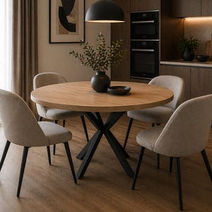 May include: A round wooden dining table with a black metal base, surrounded by four beige upholstered chairs. A black pendant light hangs above the table. The room has wooden cabinets and a framed abstract art piece.