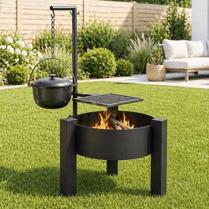 May include: A black fire pit with a hanging cooking pot and grill, set on a green lawn. The fire pit has a circular design and is supported by four legs. The background features a garden and a house.