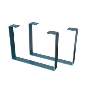 May include: Two teal-colored, U-shaped metal table legs. Each leg has a flat top with four pre-drilled holes for mounting. The legs are made of a sturdy metal and have a modern, minimalist design. Ideal for DIY furniture projects.