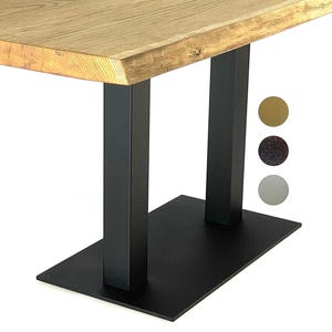 May include: A wooden table with a natural wood grain finish and a live edge. The table is supported by black metal legs. The base is a rectangular shape. The table is approximately 30 inches wide.