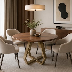 Op de afbeelding: Een moderne eethoek met een ronde houten tafel met een gouden geometrische voet, omringd door vier beige gestoffeerde stoelen. Boven de tafel hangt een beige hanglamp in de vorm van een trommel. De kamer heeft een neutraal kleurenpalet.