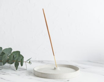 Round concrete incenses burner, minimal design and holds an intense stick upright