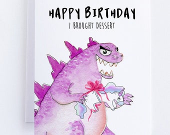 May include: A purple dinosaur with a red bow holding a pink unicorn with a rainbow mane. The card reads "Happy Birthday I brought dessert."