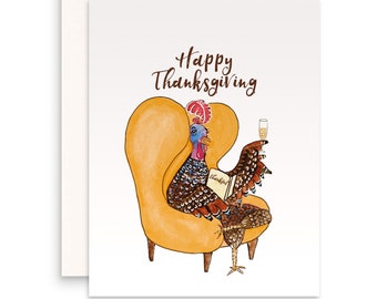 May include: A Thanksgiving greeting card featuring a cartoon turkey sitting in a yellow armchair, holding a glass of champagne and reading a book that says "Thankful". The card has the text "Happy Thanksgiving" in brown lettering.