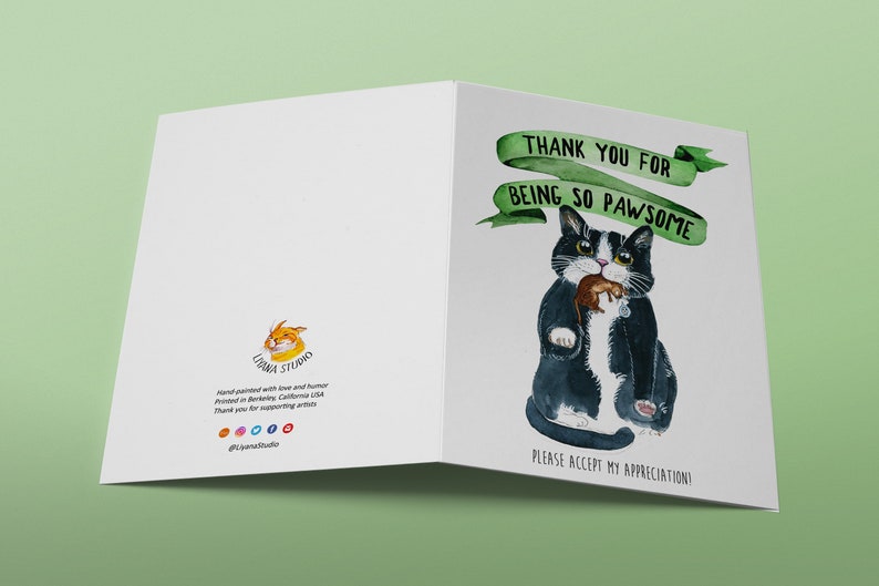 May include: A greeting card featuring a black and white cat holding a mouse. The card has green text that reads "Thank you for being so pawsome" and "Please accept my appreciation!"