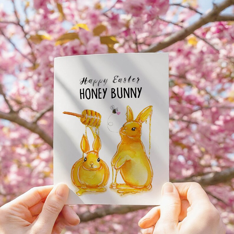 May include: A greeting card with a watercolor illustration of two honey-colored bunnies. The card reads "Happy Easter Honey Bunny".