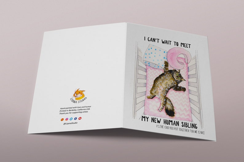 Op de afbeelding: Een kaart met een aquarel-illustratie van een kat in een wieg. De tekst op de kaart luidt: "Ik kan niet wachten om mijn nieuwe menselijke broertje of zusje te ontmoeten. P.S. De wieg die je voor me in elkaar hebt gezet is leuk."