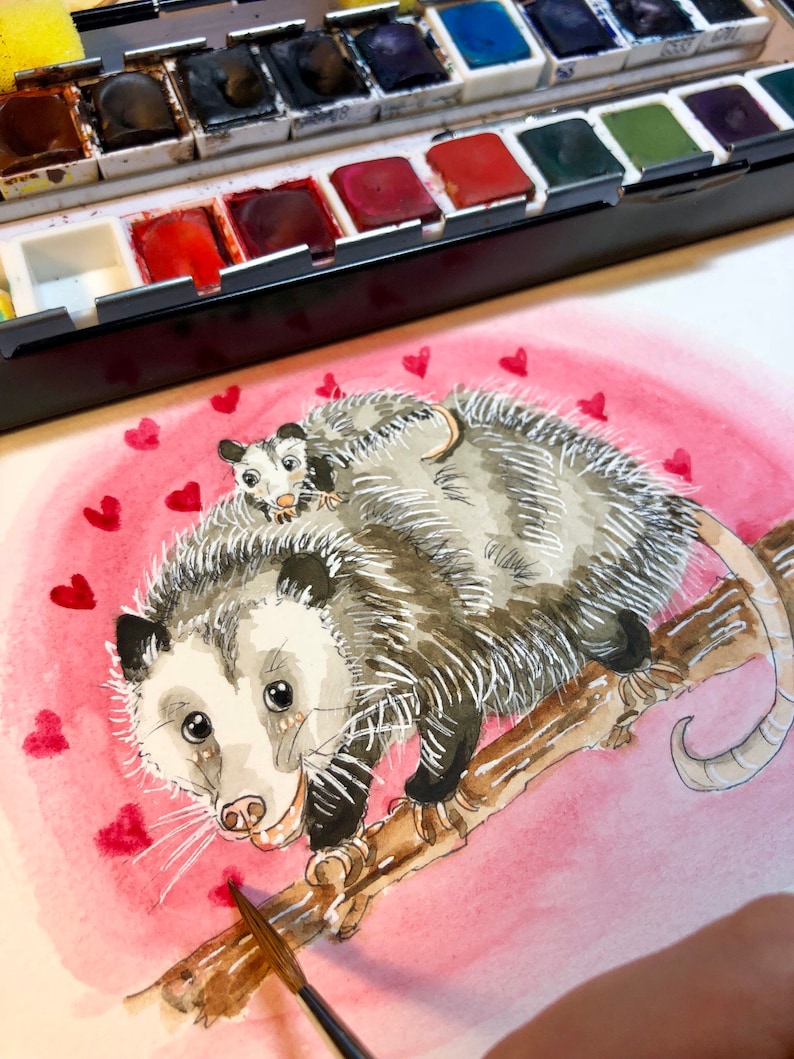 May include: Watercolor painting of two opossums on a branch with a pink background and red hearts. The opossums are facing the viewer and the larger opossum is holding the smaller opossum on its back.