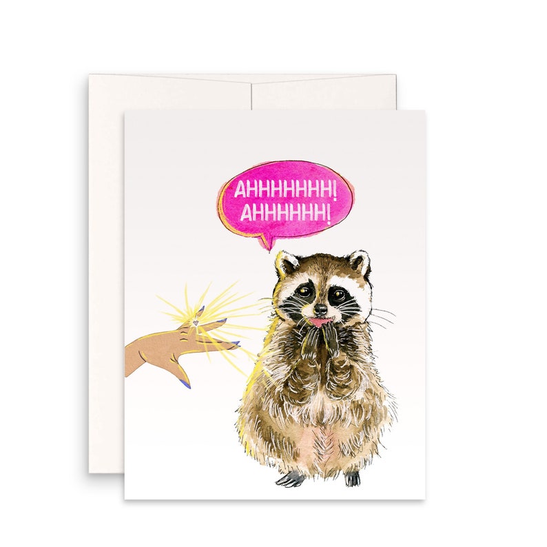 May include: A white card with a pink speech bubble that says "AHHHHHHH! AHHHHHH!" A cartoon raccoon with a ring on its finger is looking at a hand with a ring on its finger. The raccoon is saying "AHHHHHHH! AHHHHHH!" in the speech bubble.
