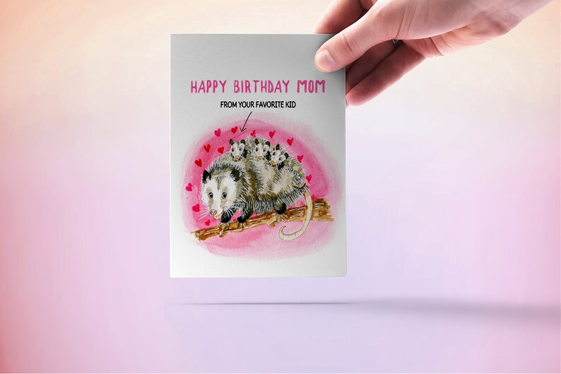 May include: A greeting card with a watercolor illustration of a possum with babies on its back. The card says "Happy Birthday Mom" and "From your favorite kid".