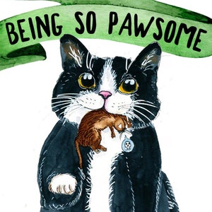 May include: A black and white cat with a white patch on its chest is holding a brown and white mouse in its mouth. The cat is looking at the viewer. The cat has a green ribbon above its head with the text "BEING SO PAWSOME" written on it.