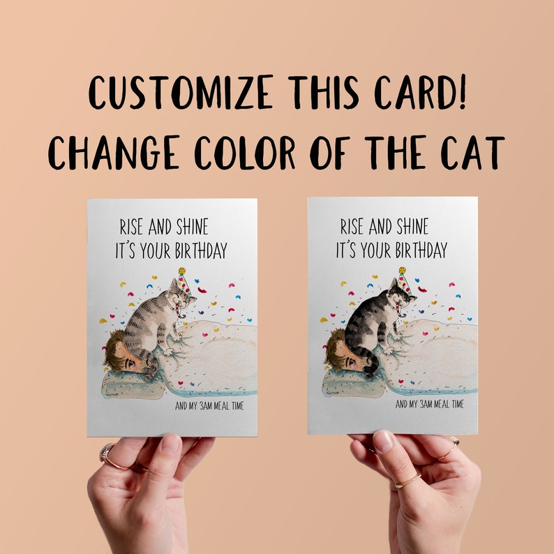 May include: A customisable birthday card featuring a cartoon cat wearing a party hat and sitting on a person's head. The card reads "Rise and Shine It's Your Birthday" and "And My 3AM Meal Time".