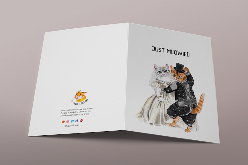 May include: A greeting card with a watercolor illustration of two cats dressed in wedding attire. The text "Just Meowed" is printed on the card.