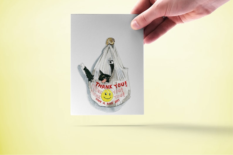 May include: A white plastic bag with a black cat inside. The bag has the text "THANK YOU!" and a smiley face printed on it.