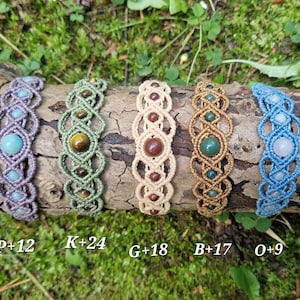Puede incluir: Cinco pulseras de macram&eacute; con detalles de piedras preciosas en varios colores, incluyendo morado, verde, beige y azul. Cada pulsera presenta una piedra preciosa &uacute;nica y se exhibe sobre un tronco de madera. Las pulseras est&aacute;n etiquetadas con letras y n&uacute;meros.