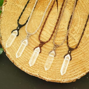 May include: Five necklaces featuring clear, hexagonal, double-terminated crystal pendants suspended on woven cord in black, beige, and various shades of brown. Each pendant is secured with a macrame knot and a small metallic bead accent.