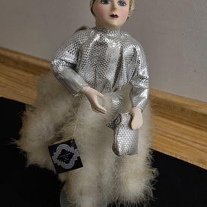Vtg. Seymour Mann 1980s porcelain art deco doll w/feathers and stand.