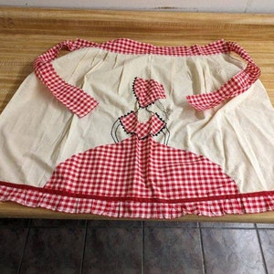 Vtg. handmade apron: lady with bonnet checkerboard clothing design.
