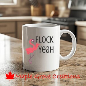 Könnte beinhalten: Eine weiße Keramik-Kaffeetasse mit einem rosa Flamingo, der eine Sonnenbrille trägt und den Text "FLOCK yeah".